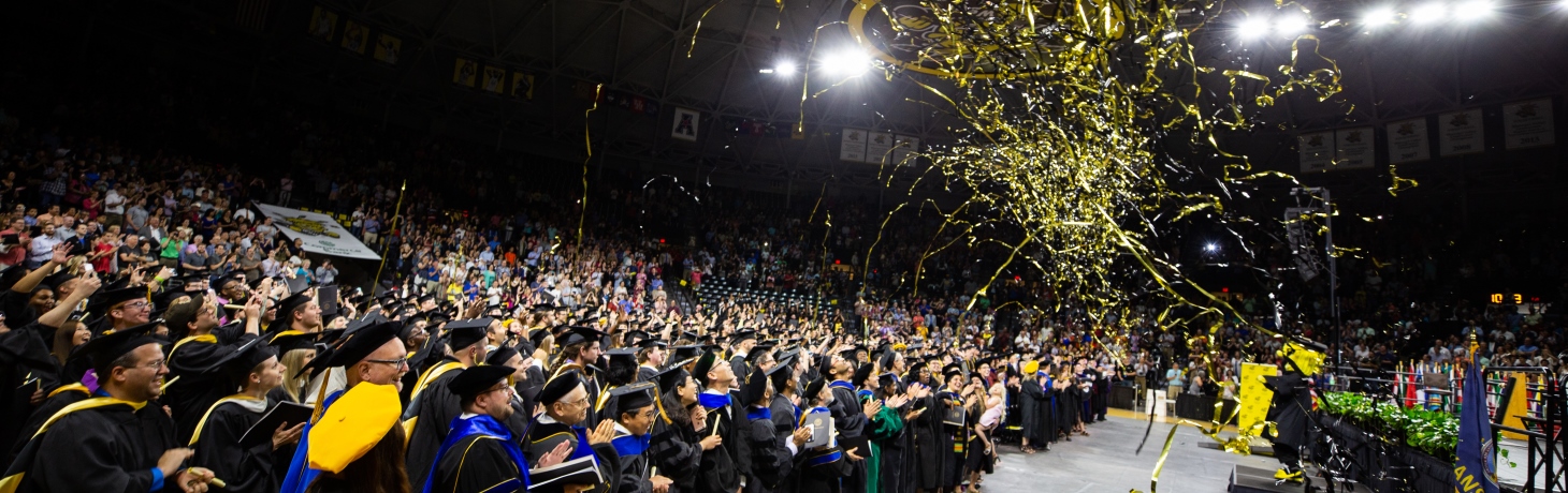 Graduation ceremony at Koch Arena with confetti.